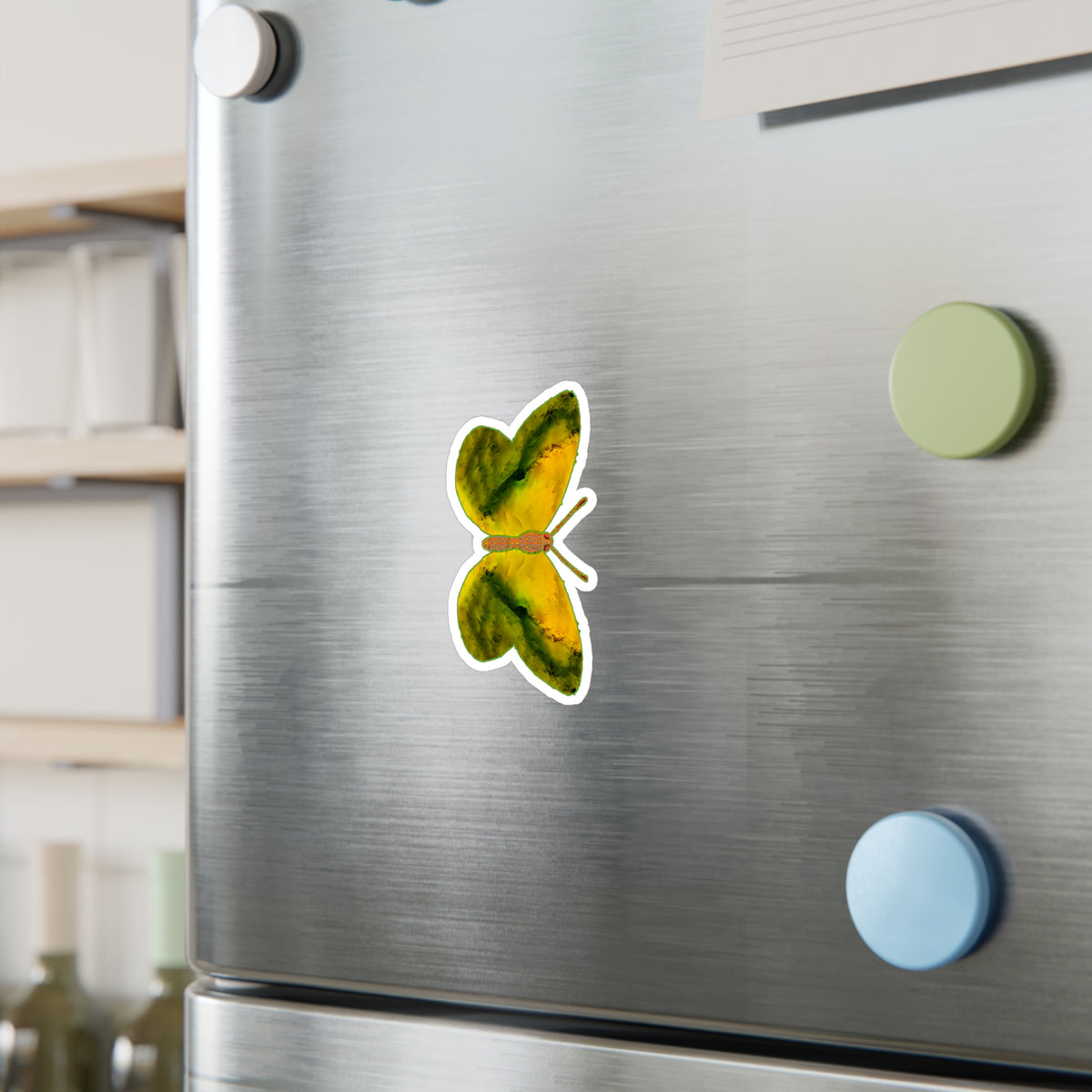 Refrigerator mock-up: butterfly decal showing yellow wings with broad dark olive bands along the edges, beside green and blue round magnets.