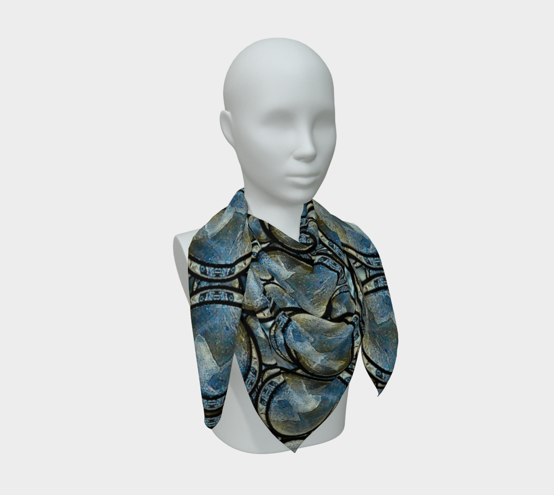 Layered blue-gray scarf with hanging ends on a mannequin; dark arcs divide cream and muted bronze patches.