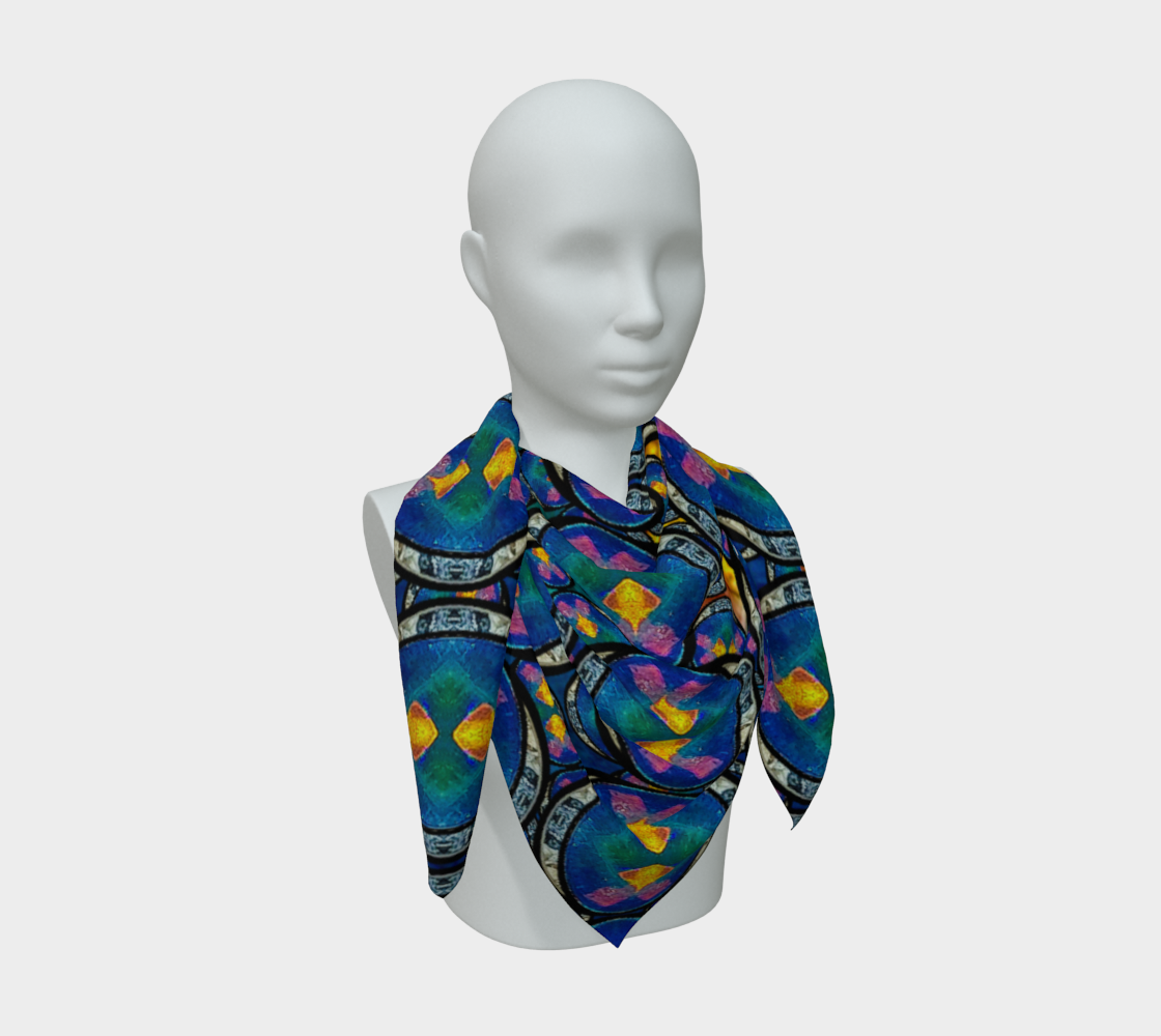 Long-ended blue scarf draped on a gray mannequin; bright angular blocks repeat between pale speckled bands.
